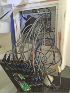 Wiring hell. 22 buttons, 8 LEDs, 2xUSB, 1xEthernet, 1x12V power, 1xAC power, 1xLCD.<br/>Note four daugherboards and a USB hub in background, and board providing dedicated GPS for the VHF